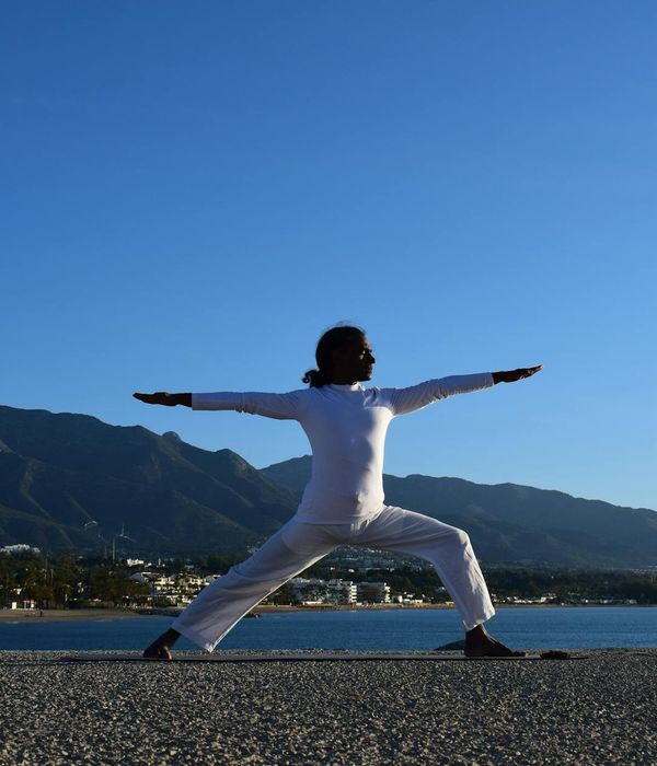 Silhouette of a man stretching against a sunrise.